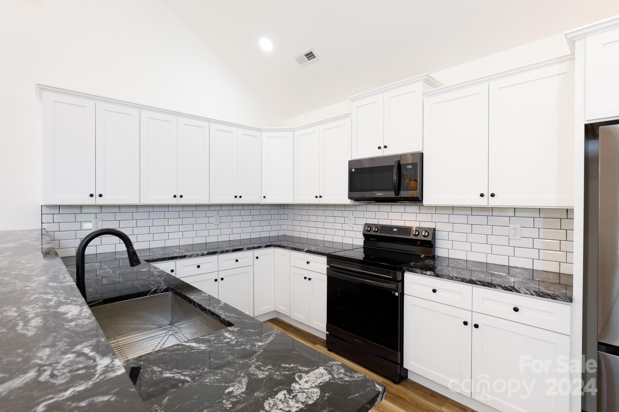 5040 Mt Gallant Road Rock Hill, SC 29732 - Photo 7 of 38 a kitchen with granite countertop a sink stainless steel appliances and white cabinets