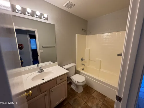 a bathroom with a sink a toilet a mirror and shower