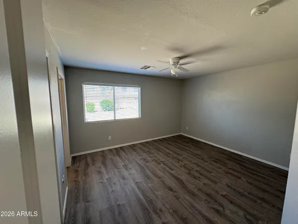 an empty room with wooden floor and windows