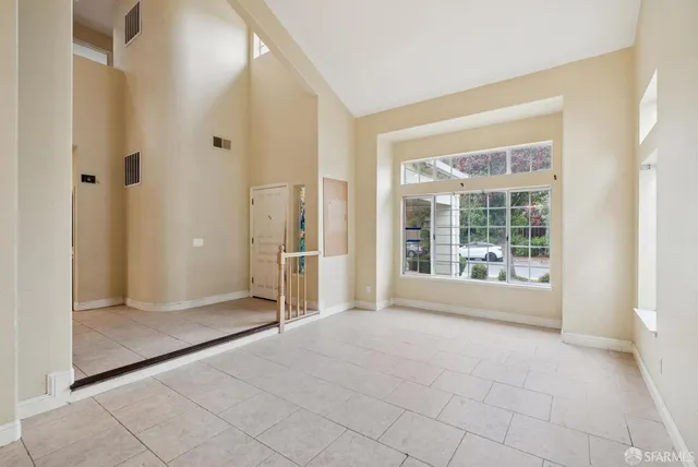 a view of an empty room with wooden floor fireplace and a window