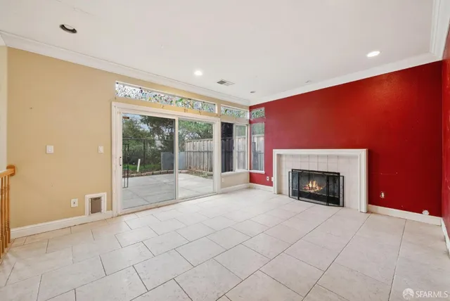 a view of an empty room with a fireplace and a window