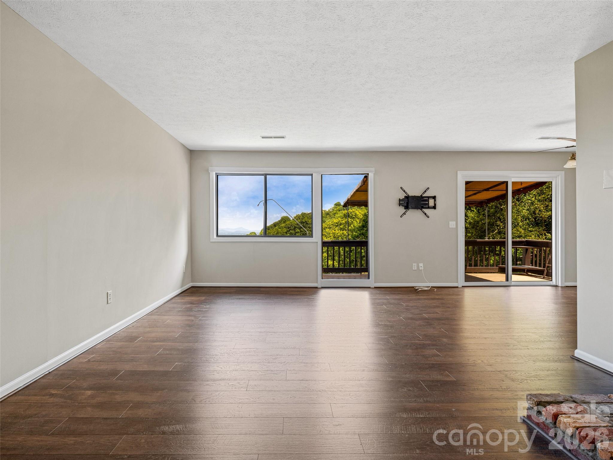 128 Country Ridge Road Hendersonville, NC 28739 - Photo 7 of 48 an empty room with wooden floor and windows