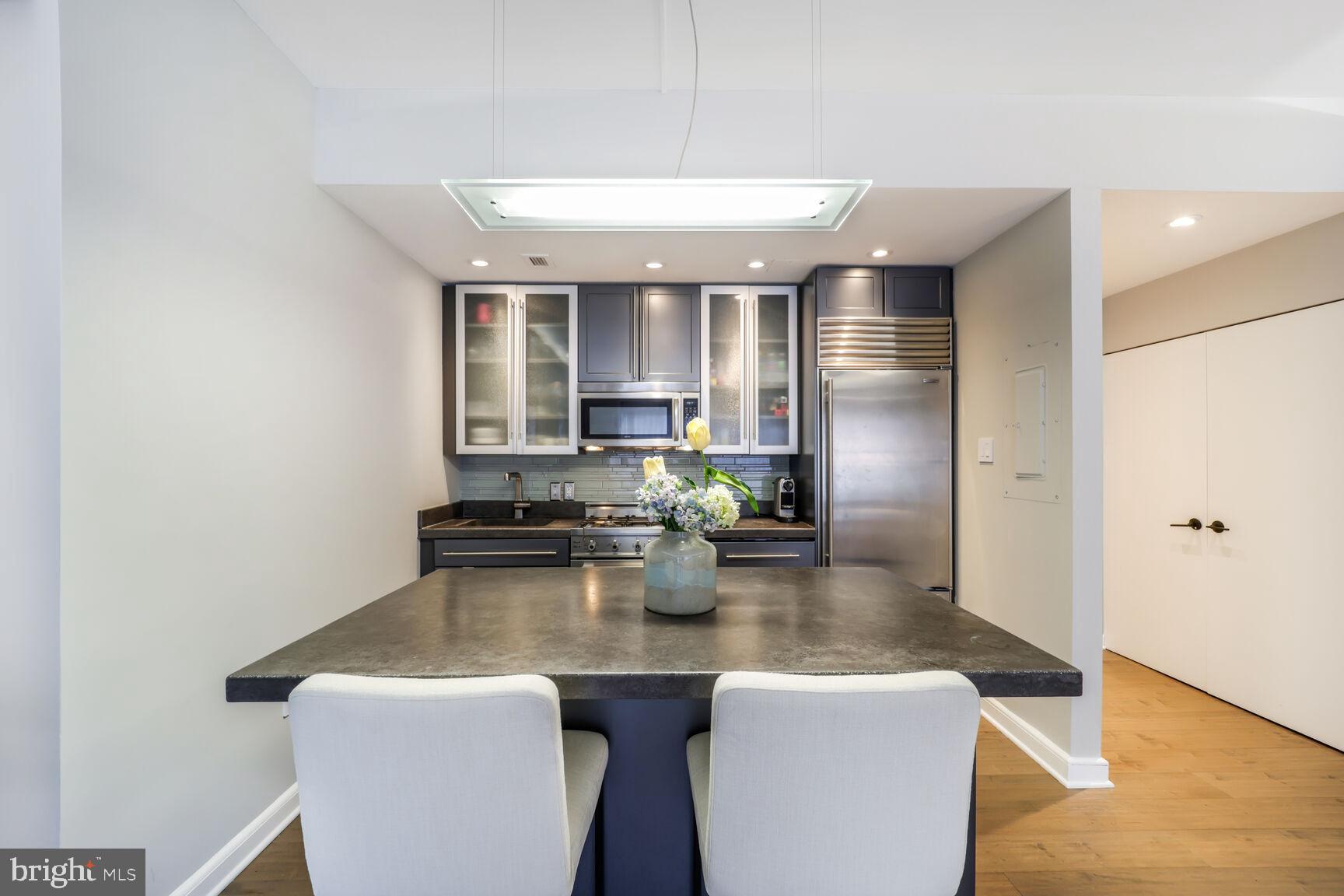 3251 Prospect Street Northwest, Unit 410 Washington, DC 20007 - Photo 6 of 16 a kitchen with sink refrigerator and dining table