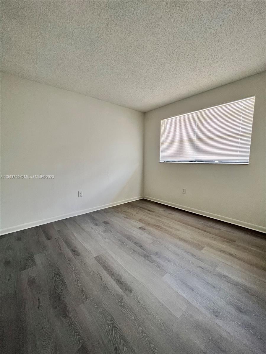 Welleby Sunrise, FL 33351 - Photo 7 of 13 an empty room with wooden floor