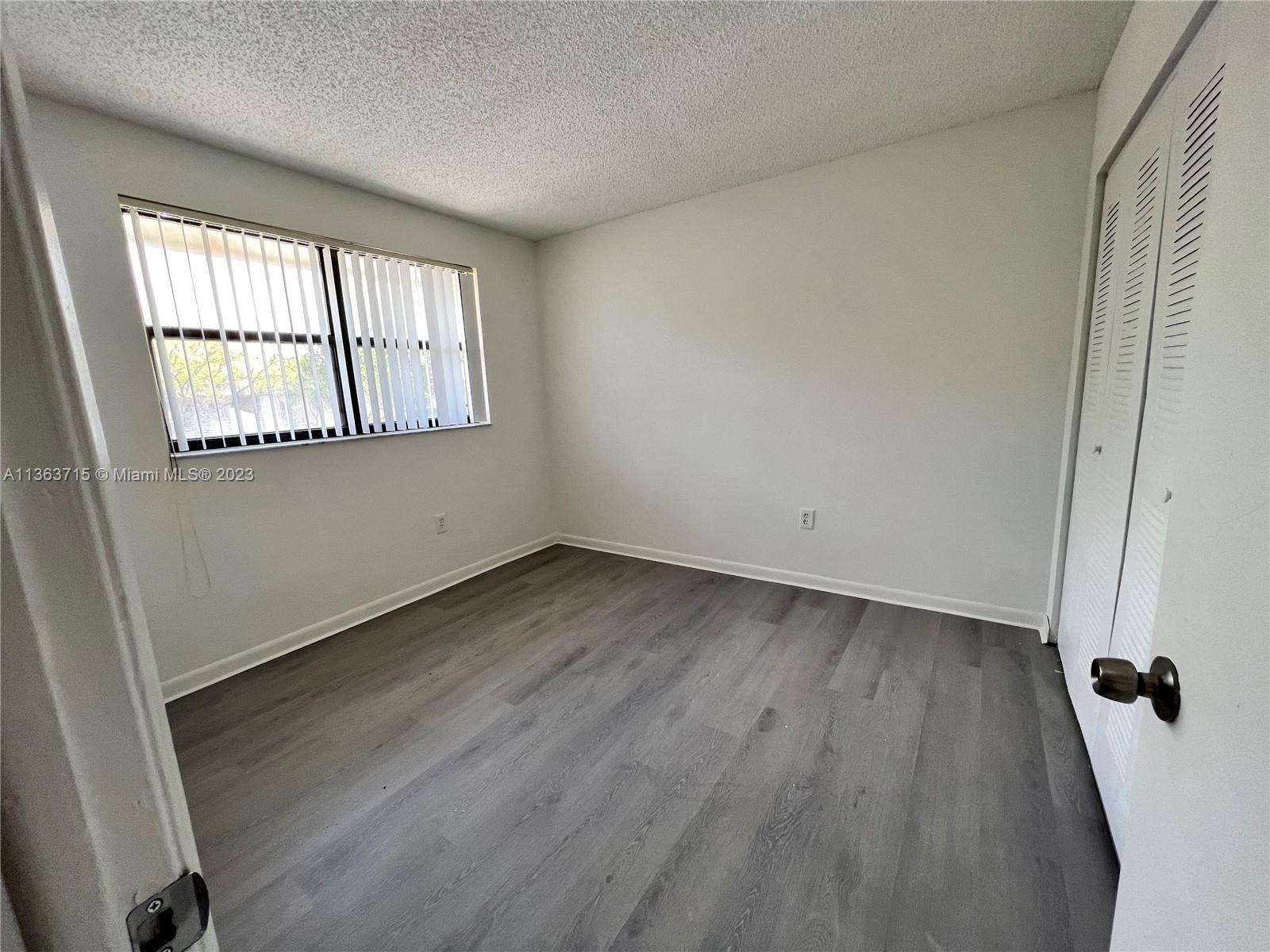 Welleby Sunrise, FL 33351 - Photo 8 of 13 an empty room with wooden floor and windows