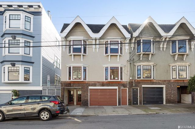 a car parked in front of a big house