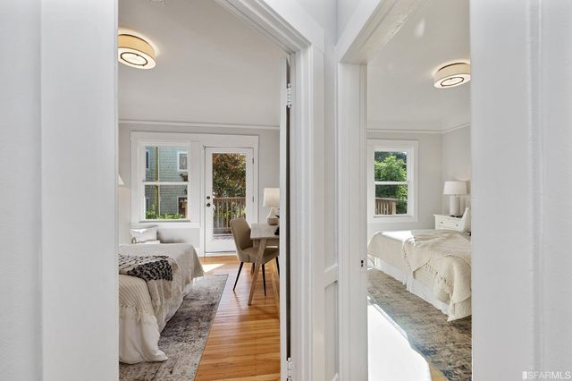 a view of a hallway with wooden floor and living room