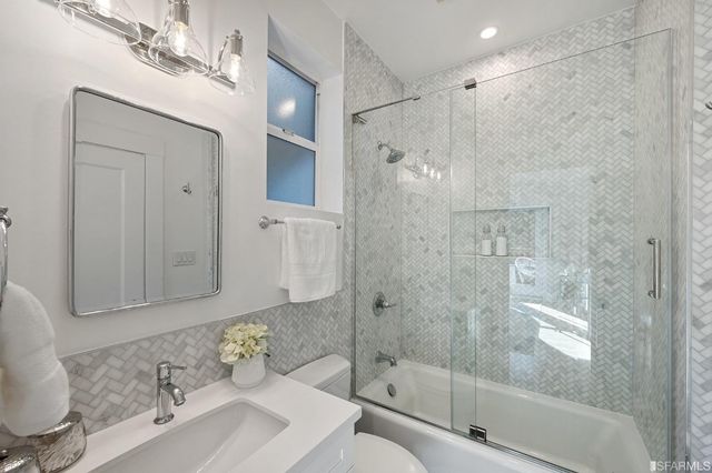 a bathroom with a sink shower and a mirror