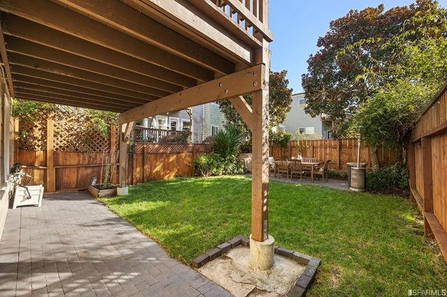 a view of a backyard with table and chairs and a tree