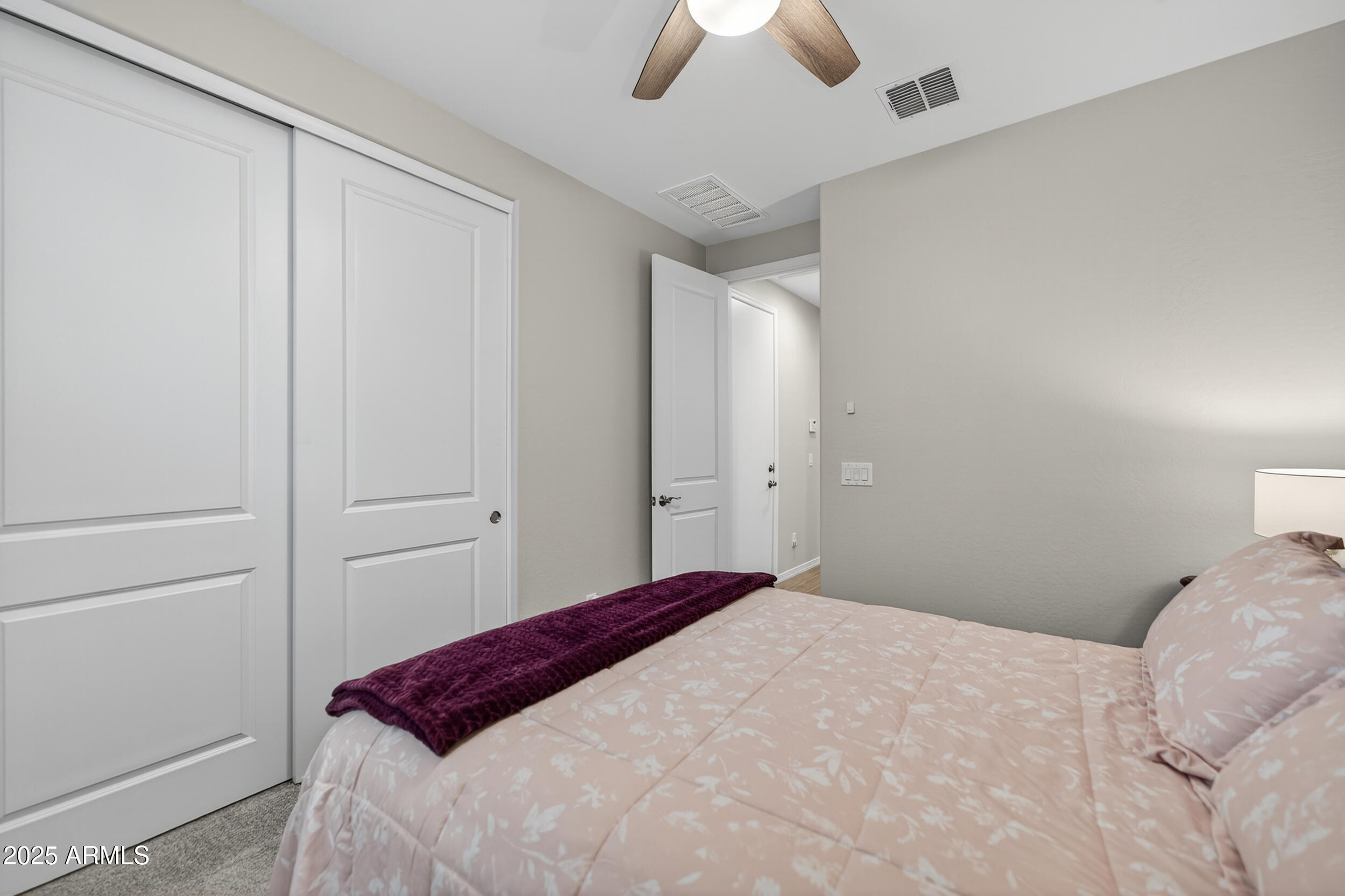 10218 West Piccadilly Road Avondale, AZ 85392 - Photo 14 of 28 a bedroom with a bed and a chandelier