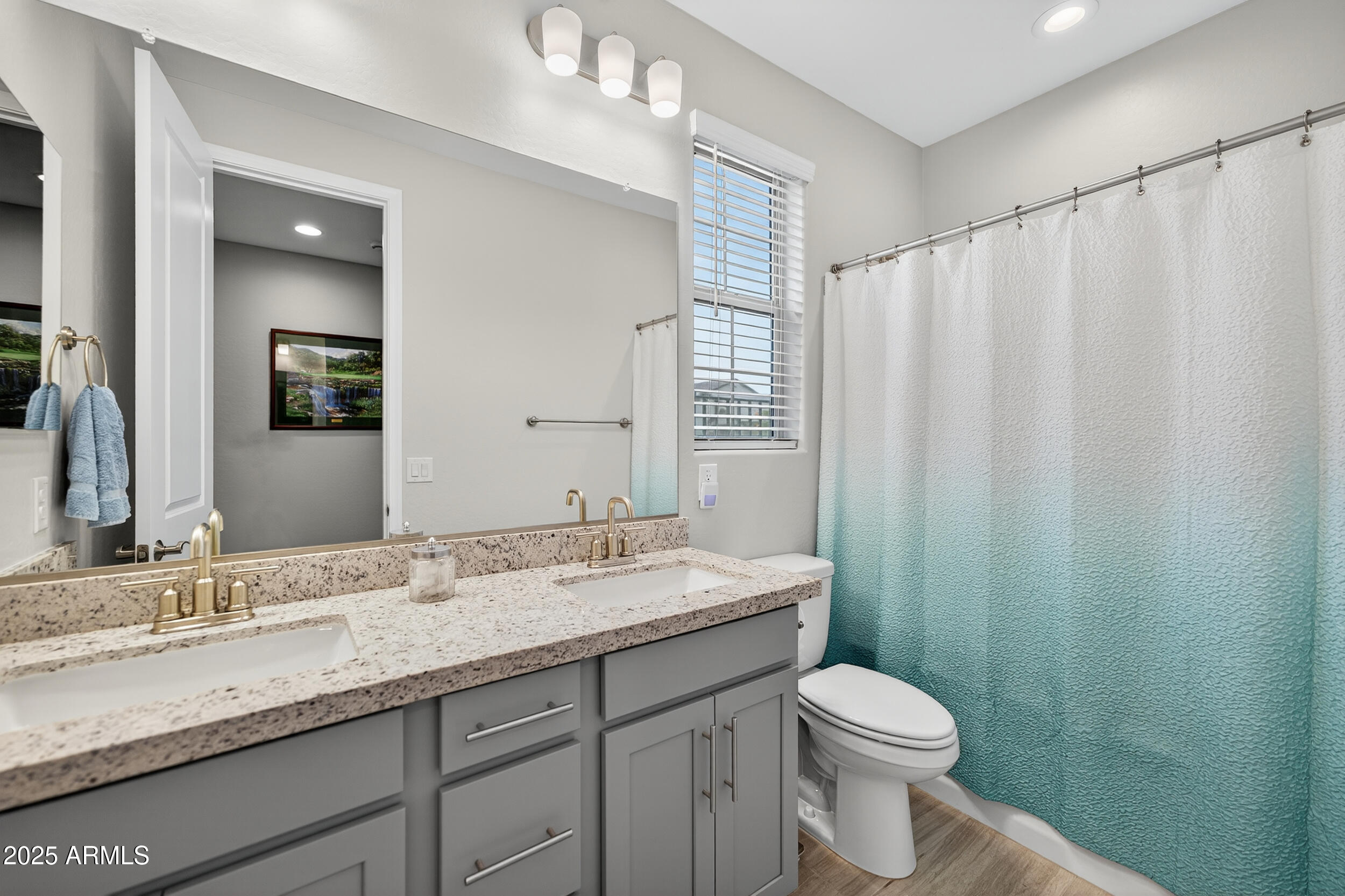 10218 West Piccadilly Road Avondale, AZ 85392 - Photo 18 of 28 a bathroom with a granite countertop sink toilet and a mirror