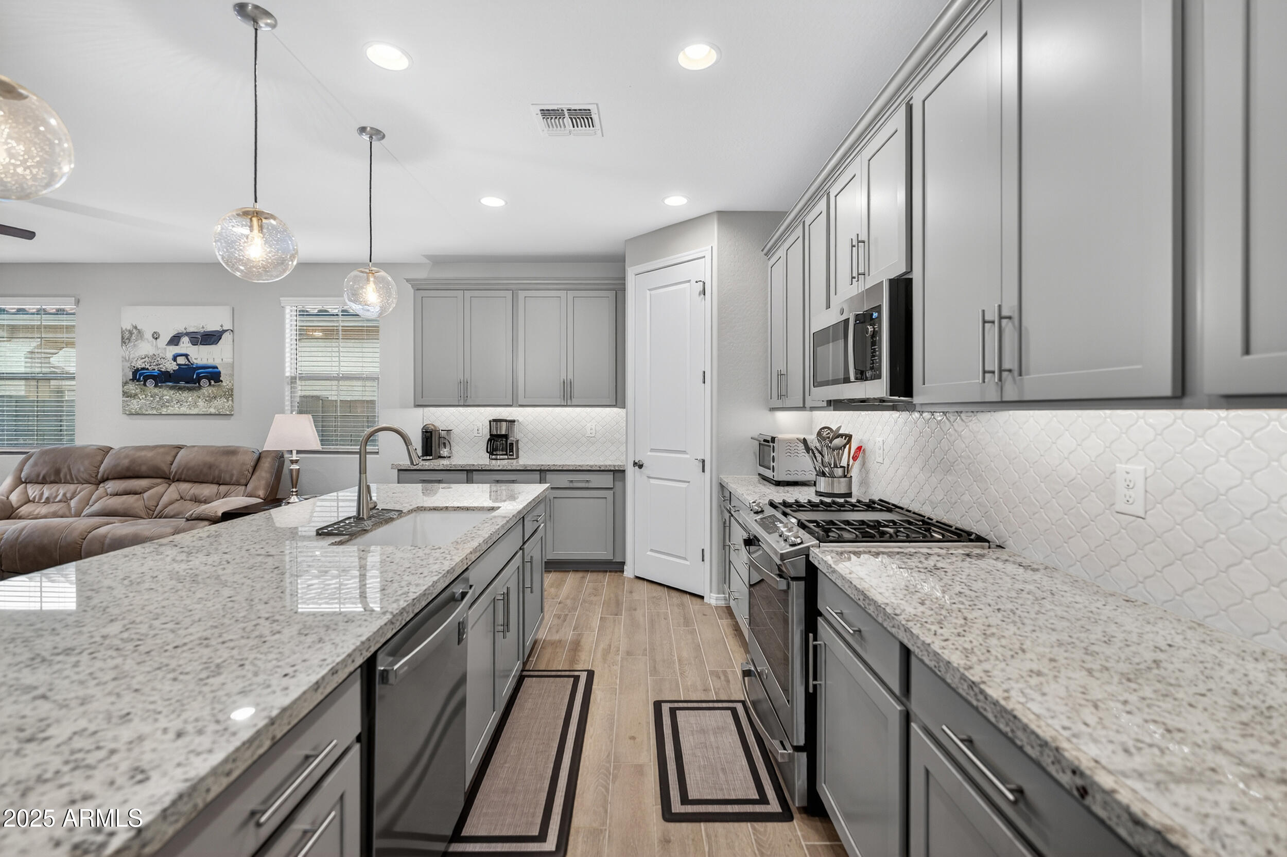 10218 West Piccadilly Road Avondale, AZ 85392 - Photo 6 of 28 a kitchen with stainless steel appliances granite countertop a stove a sink and a microwave