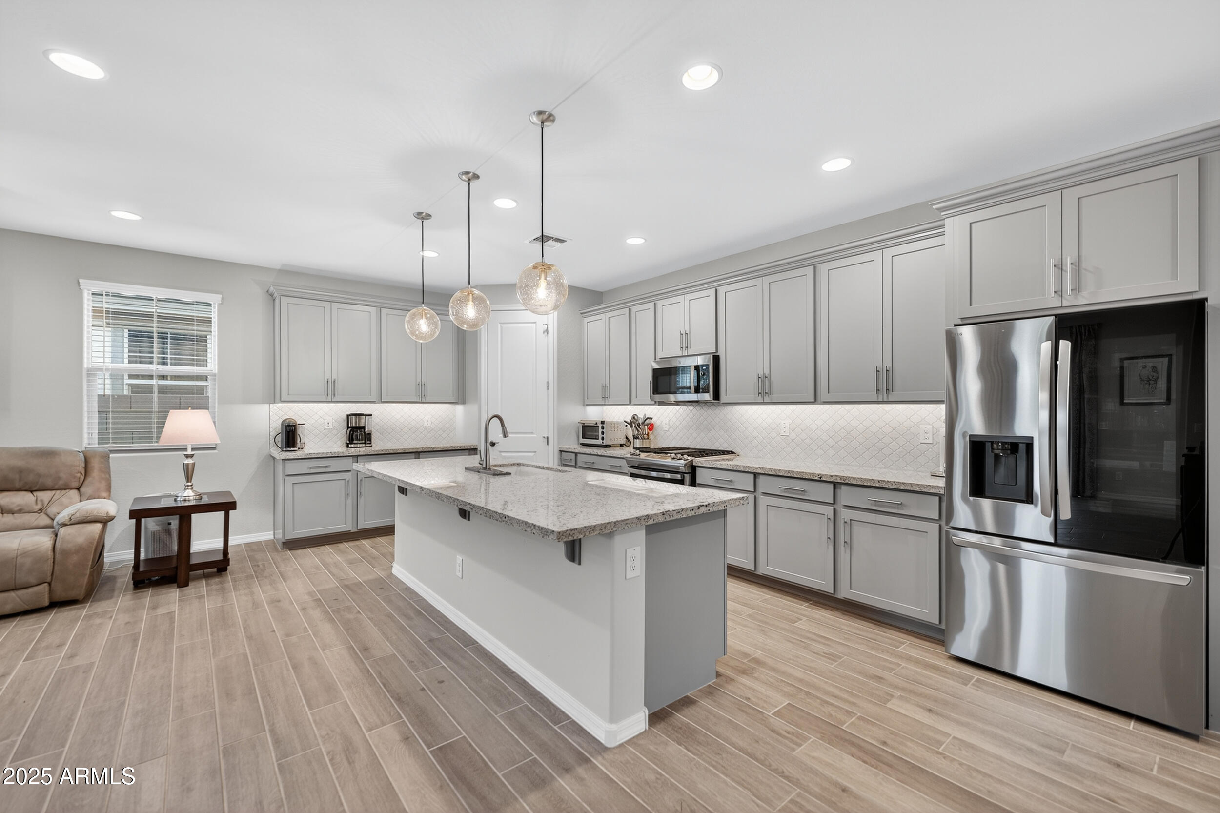 10218 West Piccadilly Road Avondale, AZ 85392 - Photo 7 of 28 a large kitchen with stainless steel appliances a large counter top a sink a stove and a refrigerator