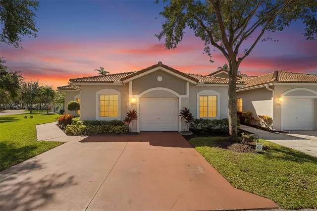 a front view of a house with a garden and yard