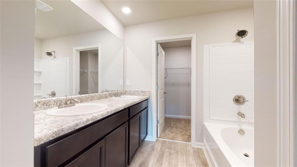 145 Weldon Road McDonough, GA 30253 - Photo 21 of 32 a bathroom with a granite countertop sink a mirror and a bathtub