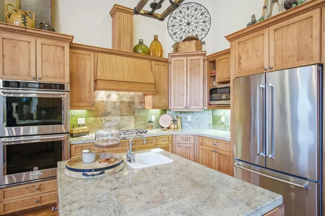 a kitchen with stainless steel appliances a stove a refrigerator and a microwave