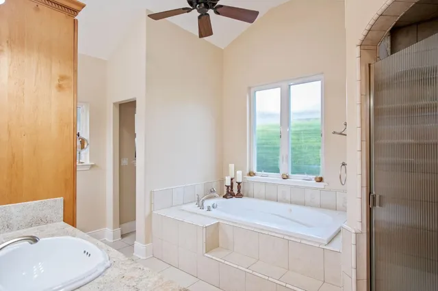 a spacious bathroom with a tub sink and mirror