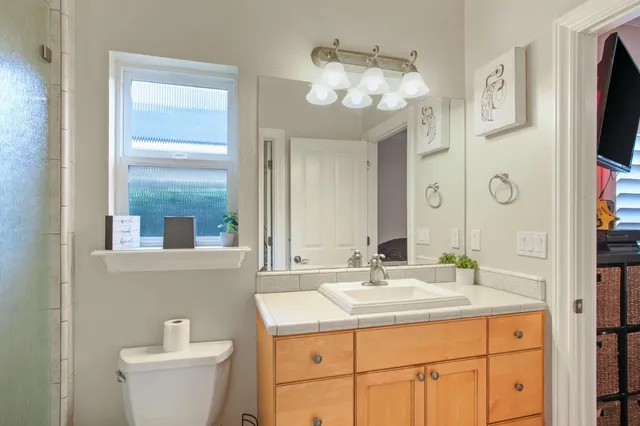 a bathroom with a sink a large mirror and a toilet