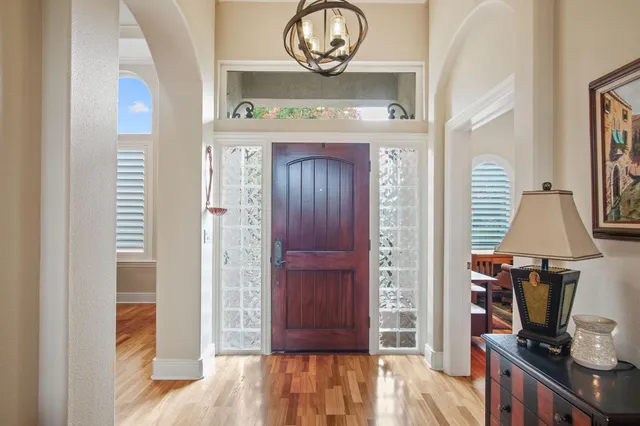 a view of a hallway with entryway wooden floor and front door