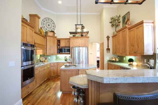 a kitchen with stainless steel appliances granite countertop a sink stove and refrigerator