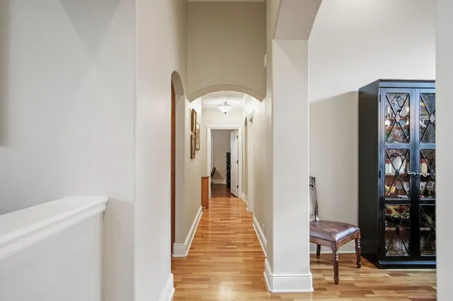 a view of a hallway with wooden floor and windows