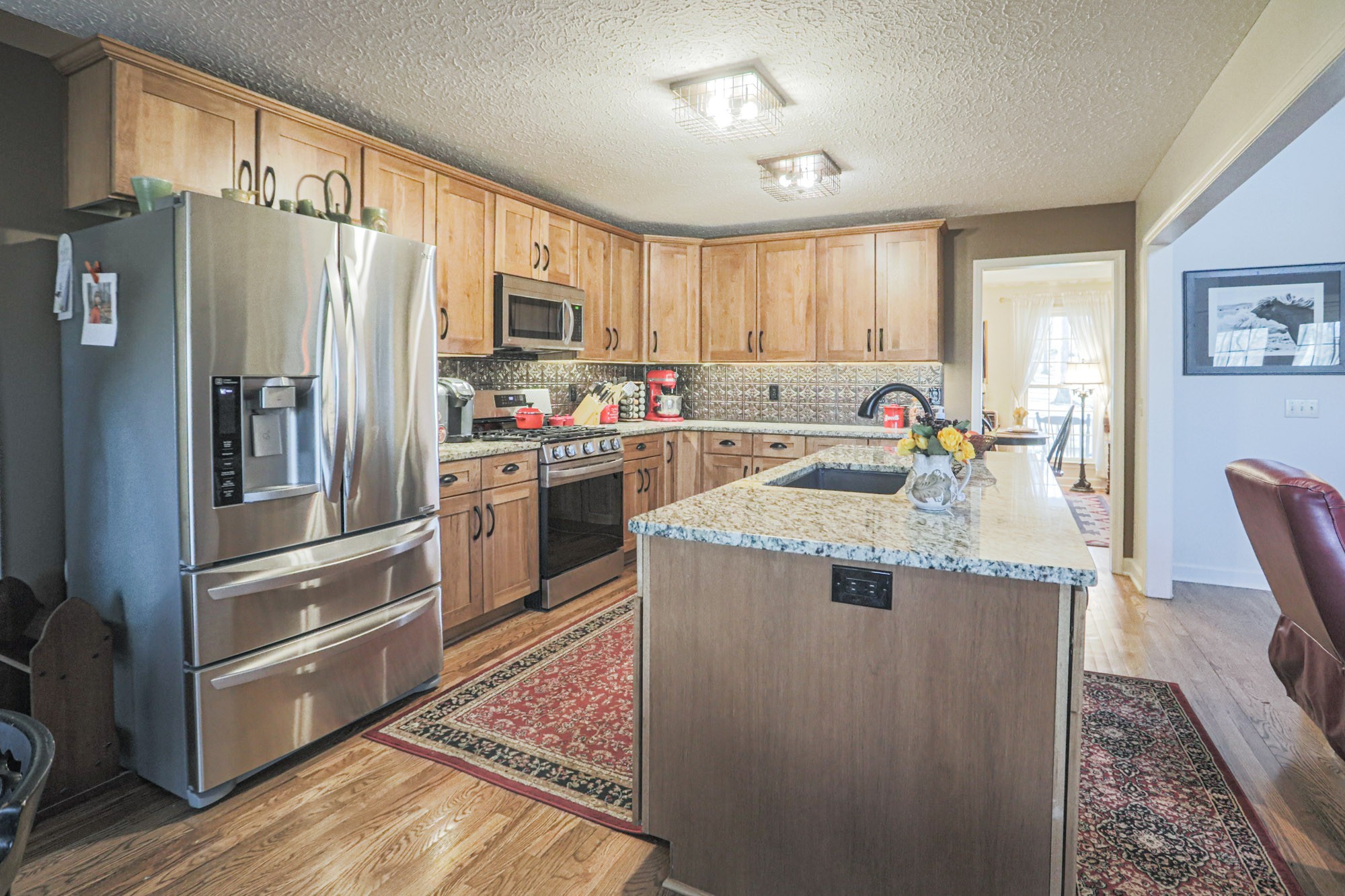 7126 Elrod Road Fairview, TN 37062 - Photo 29 of 36 a kitchen with stainless steel appliances granite countertop a refrigerator a stove a sink and a refrigerator with wooden floor