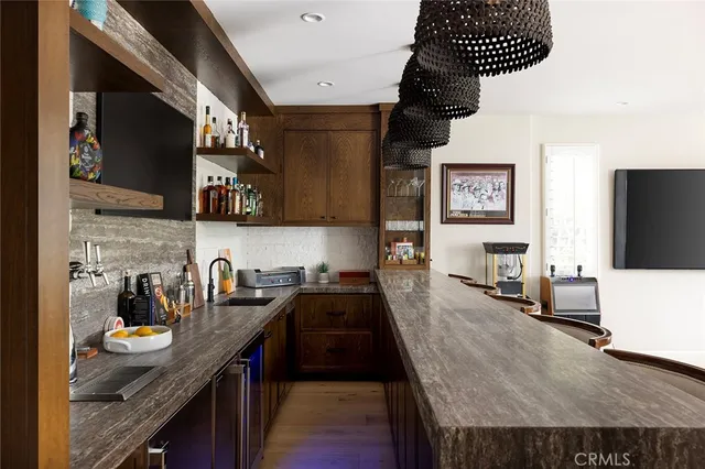 a living room with stainless steel appliances furniture and a flat screen tv