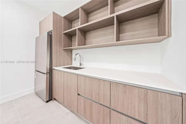 a kitchen with kitchen island a stove a sink and a refrigerator with wooden floor