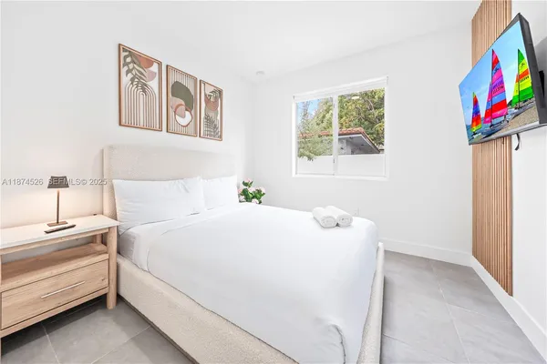 a spacious bedroom with a bed a couch and a window
