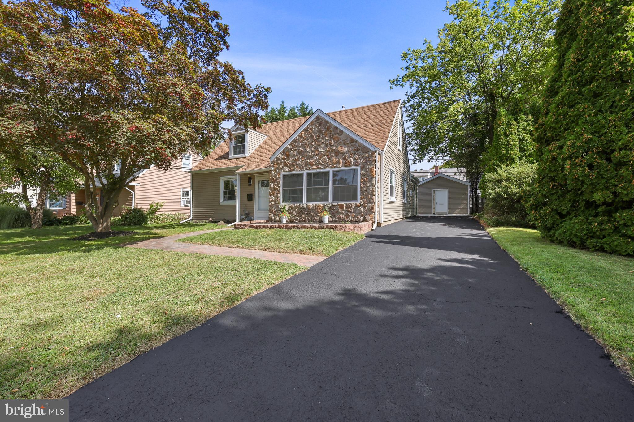 a front view of a house with a yard and trees