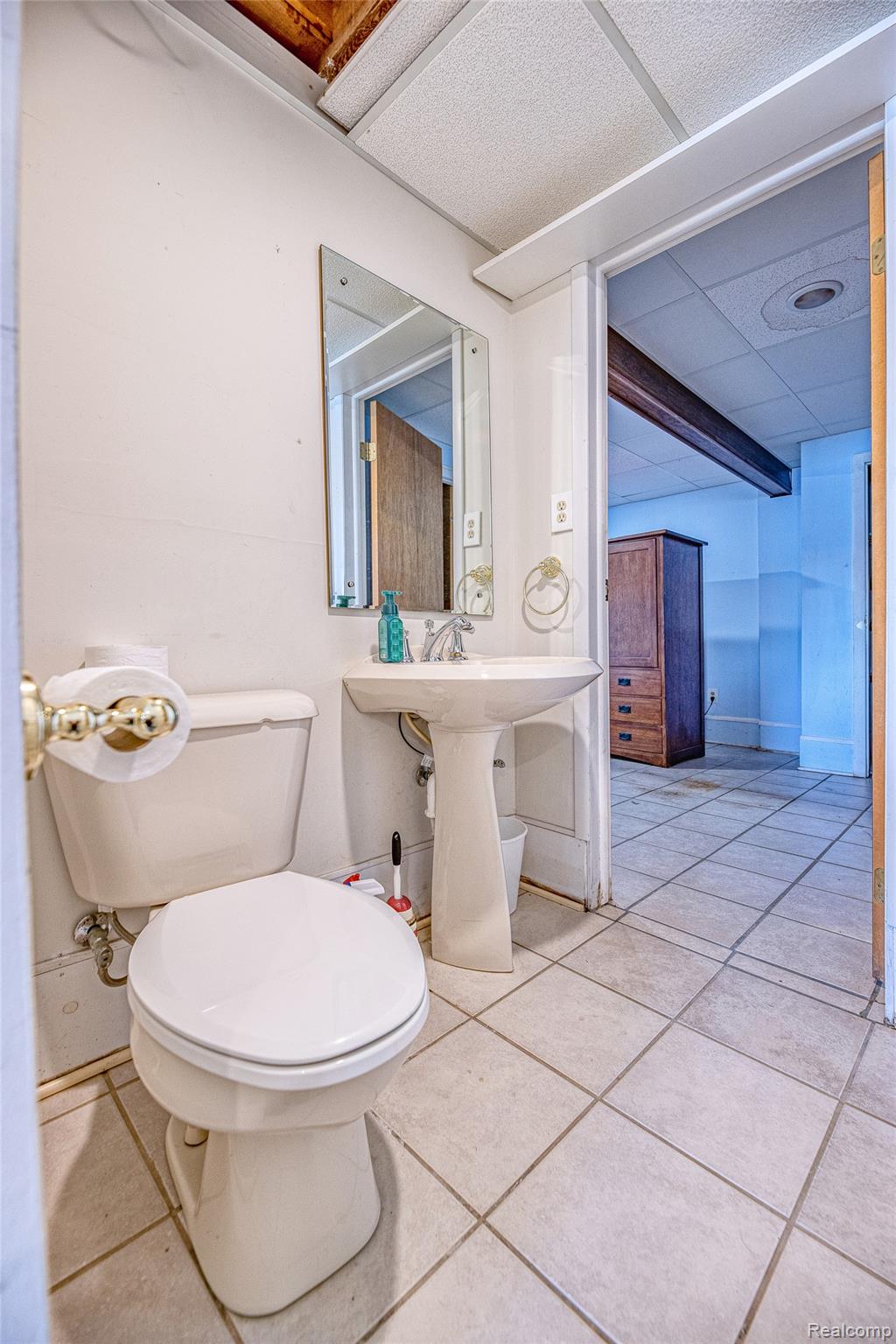 2855 Farmers Creek Road Metamora, MI 48455 - Photo 30 of 51 White pedestal sink with a wall-mounted mirror, ceramic tile flooring, and a drop ceiling