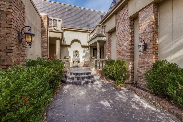 a front view of a house with garden and chairs
