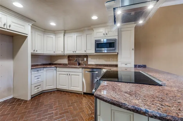 a kitchen with stainless steel appliances granite countertop a sink and cabinets