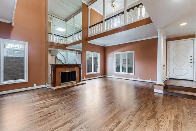 a view of an empty room with a fireplace and wooden floor