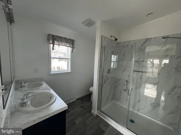 a bathroom with a sink shower and a mirror