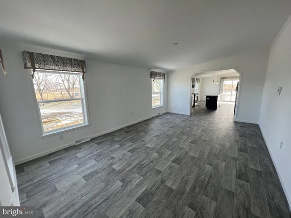 a view of a livingroom with wooden floor and a fireplace