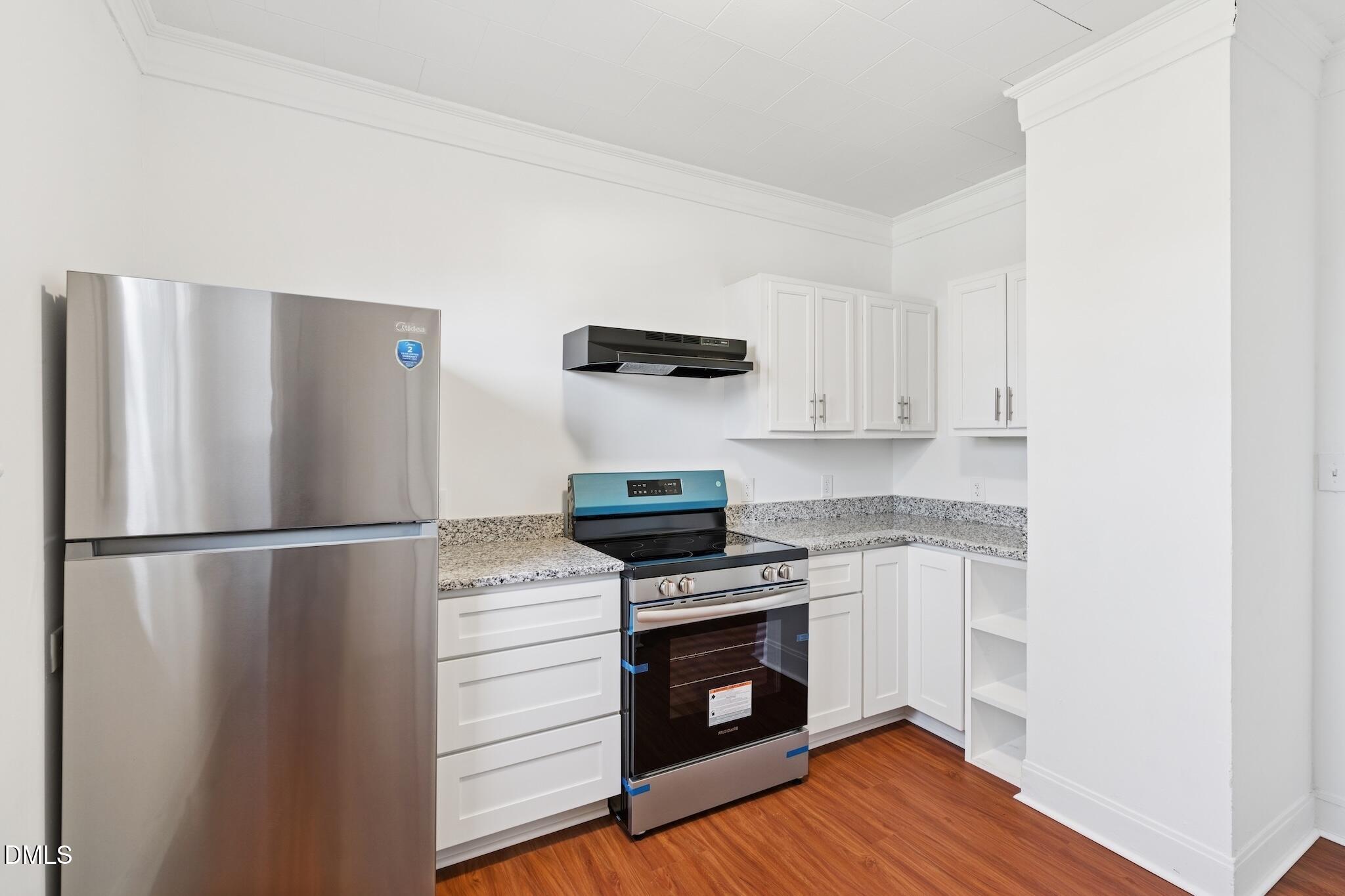 705 North Driver Street Durham, NC 27703 - Photo 18 of 46 a kitchen with a refrigerator stove and white cabinets