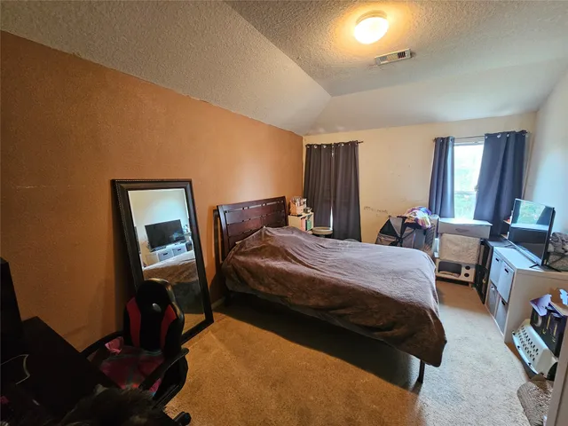 a bedroom with bed chair and window