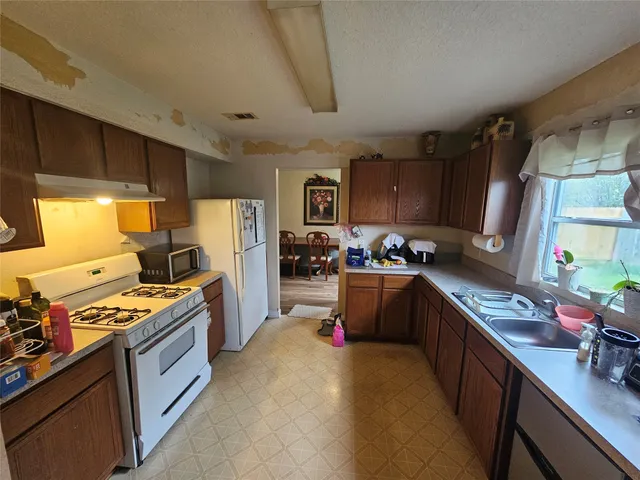 a kitchen with stainless steel appliances granite countertop a stove refrigerator sink and cabinets