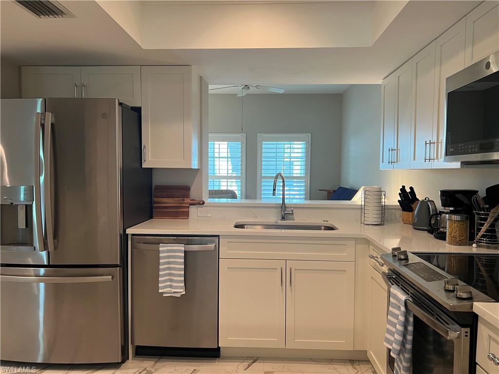 5897 Chanteclair Drive, Unit 314A Naples, FL 34108 - Photo 13 of 21 a kitchen with stainless steel appliances white cabinets and a refrigerator