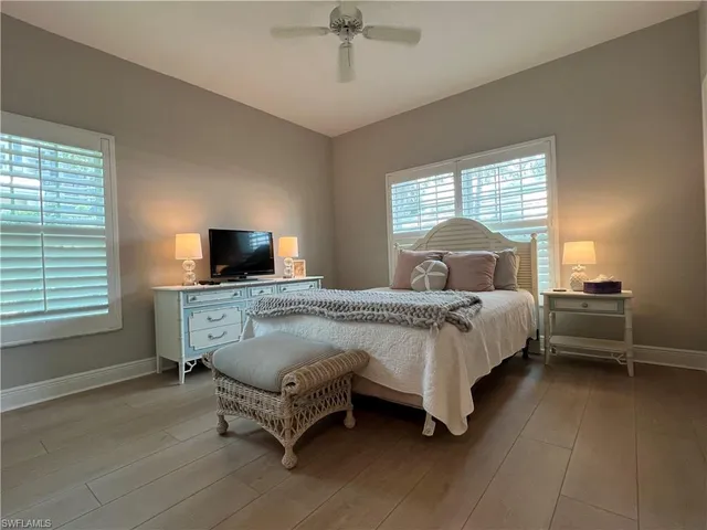 a bedroom with a bed a window and lamp