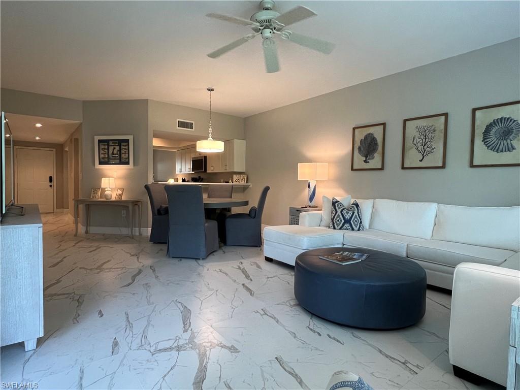5897 Chanteclair Drive, Unit 314A Naples, FL 34108 - Photo 4 of 21 a living room with furniture and a chandelier