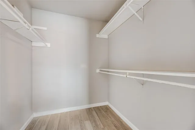 a view of walk in closet with empty racks