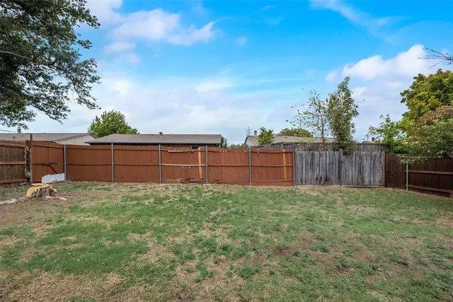 a view of a backyard with wooden fence