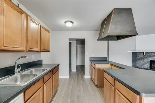 a kitchen with stainless steel appliances granite countertop a sink a stove and a wooden cabinets