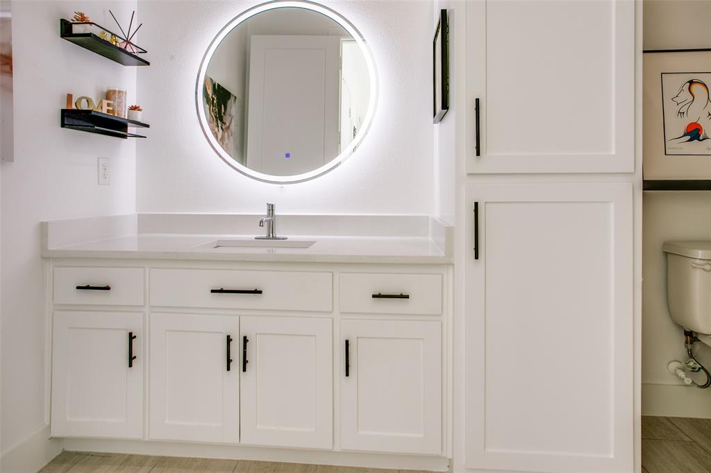 7141 Northaven Road Dallas, TX 75230 - Photo 15 of 38 a bathroom with a sink and a mirror