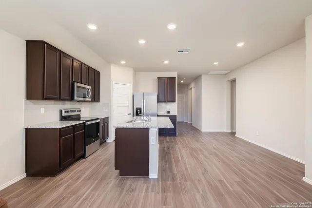 a kitchen with stainless steel appliances wooden floors and wooden cabinets