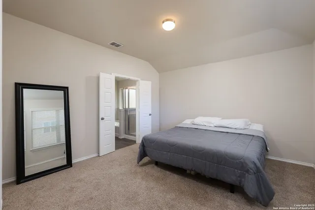 a bedroom with a bed and a mirror