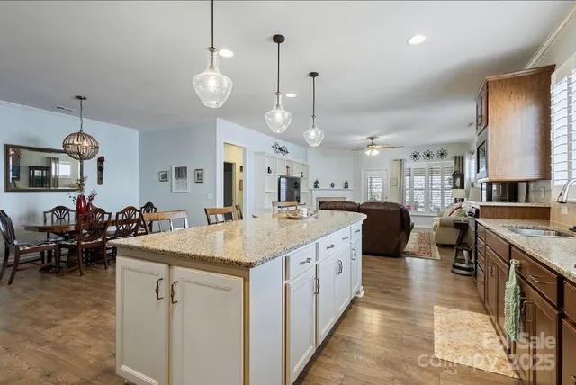 a large kitchen with kitchen island a island a stove a sink a dining table and chairs