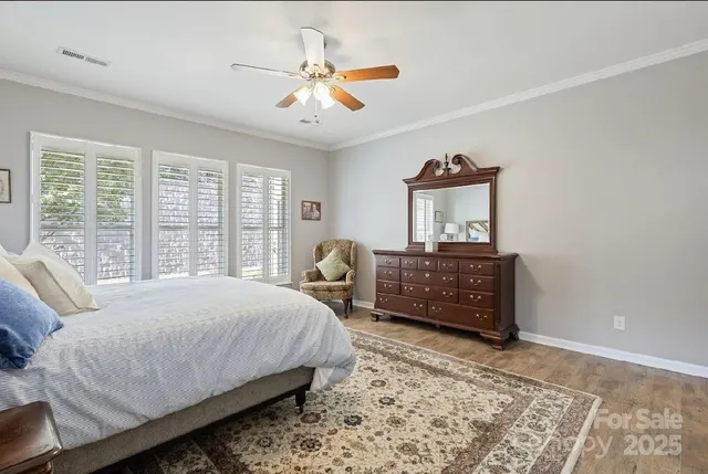 a bedroom with a bed dresser and wooden floor